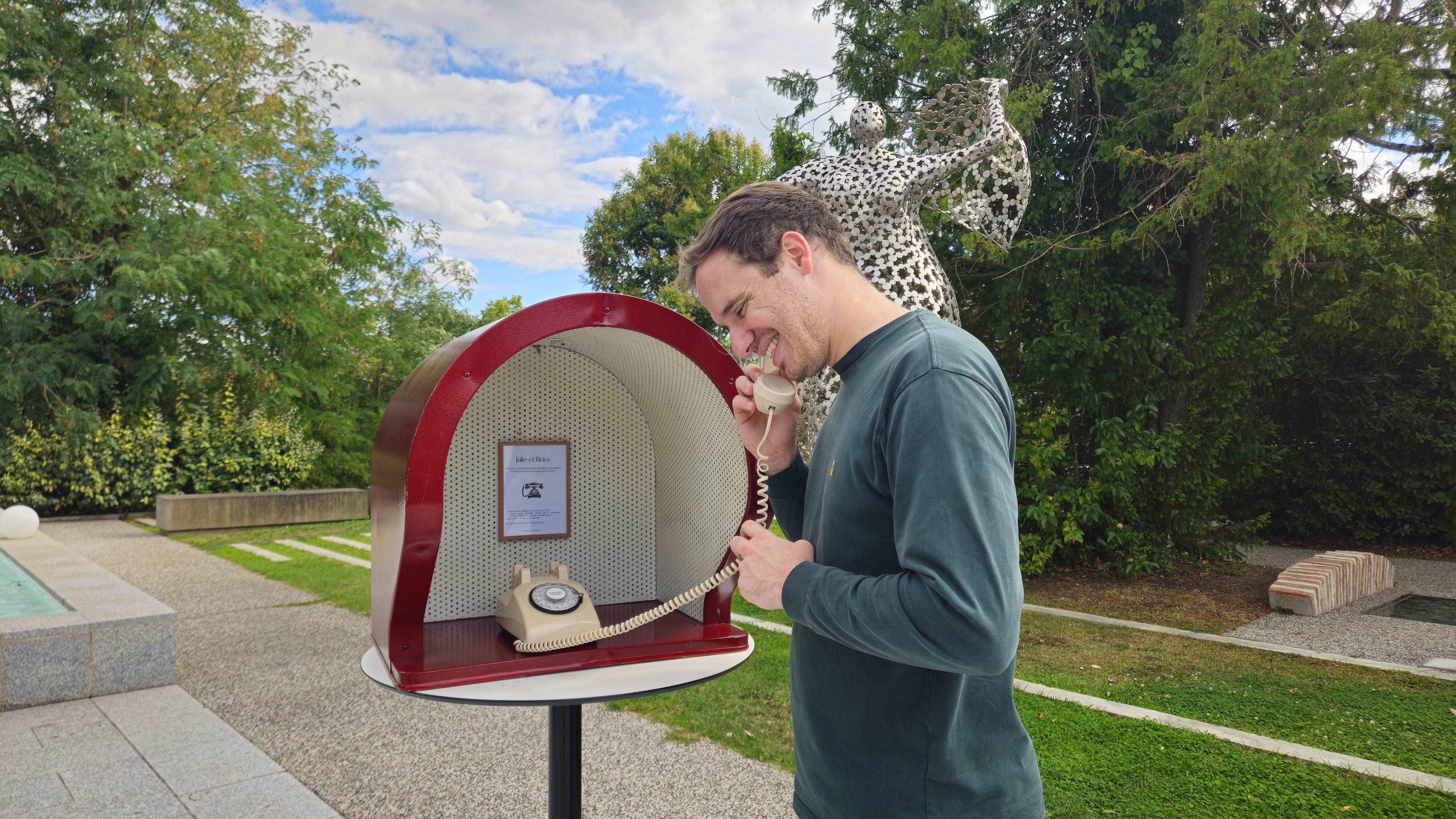 Invité enregistrant un message dans la cabine téléphonique Souvenirs Sonores